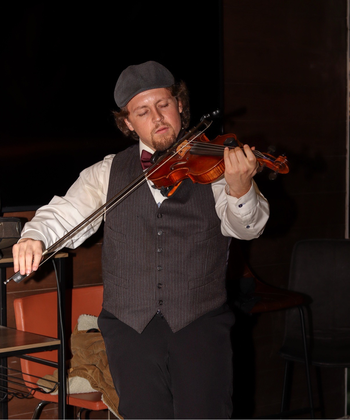 Jake playing violin at a wedding in a tuxedo and cowboy hat